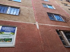 Небольшая камера внешнего видео обзора установленная на стене жилого многоквартирного дома