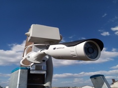 Мощьная уличная камера видеослежения установлена на крыше высотного здания